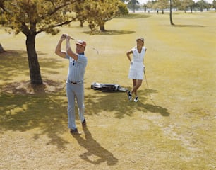 Ein Mann und eine Frau spielen Golf auf einem Feld