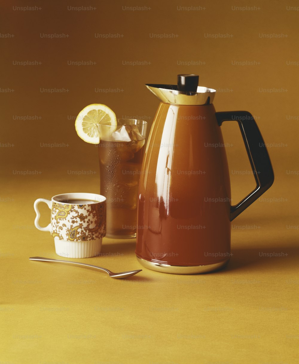 una jarra de té junto a una taza de té