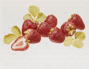 a group of strawberries with leaves on a white background