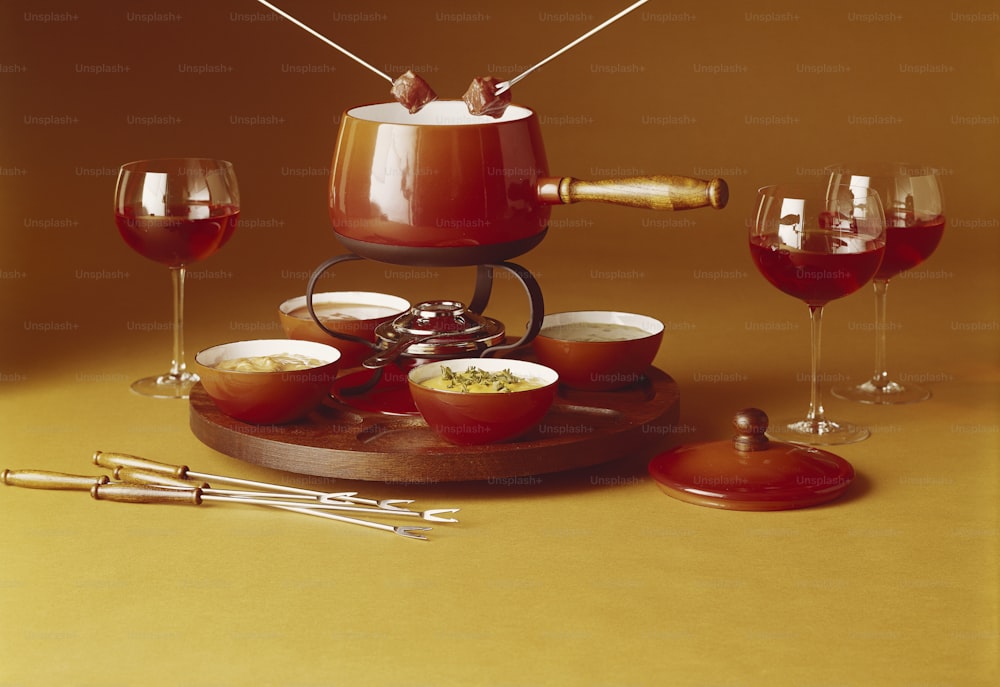 uma mesa coberta com tigelas de comida e taças de vinho