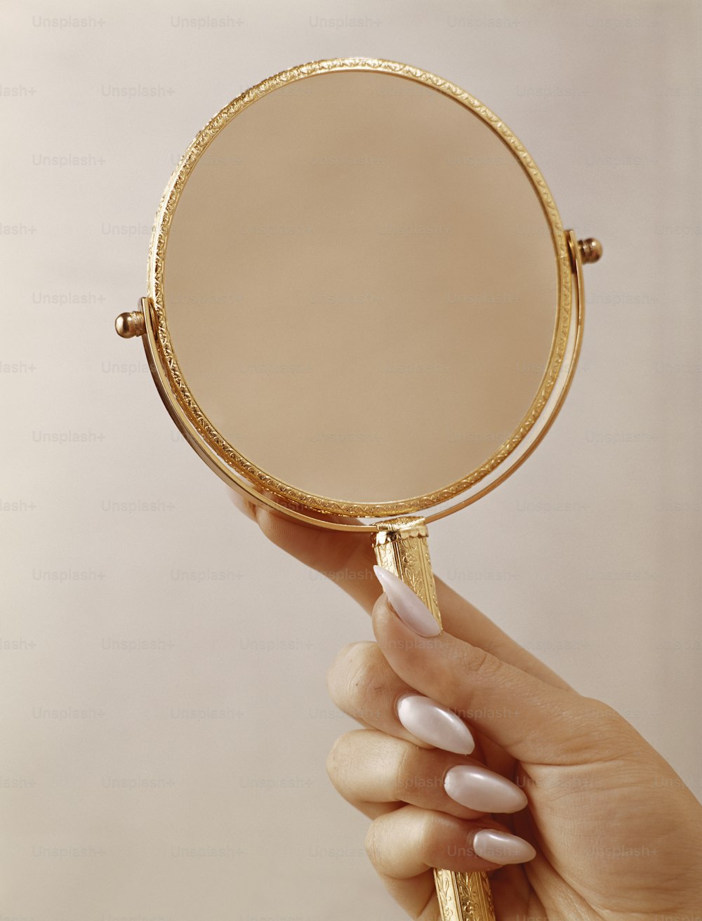 une personne tenant un miroir avec sa main