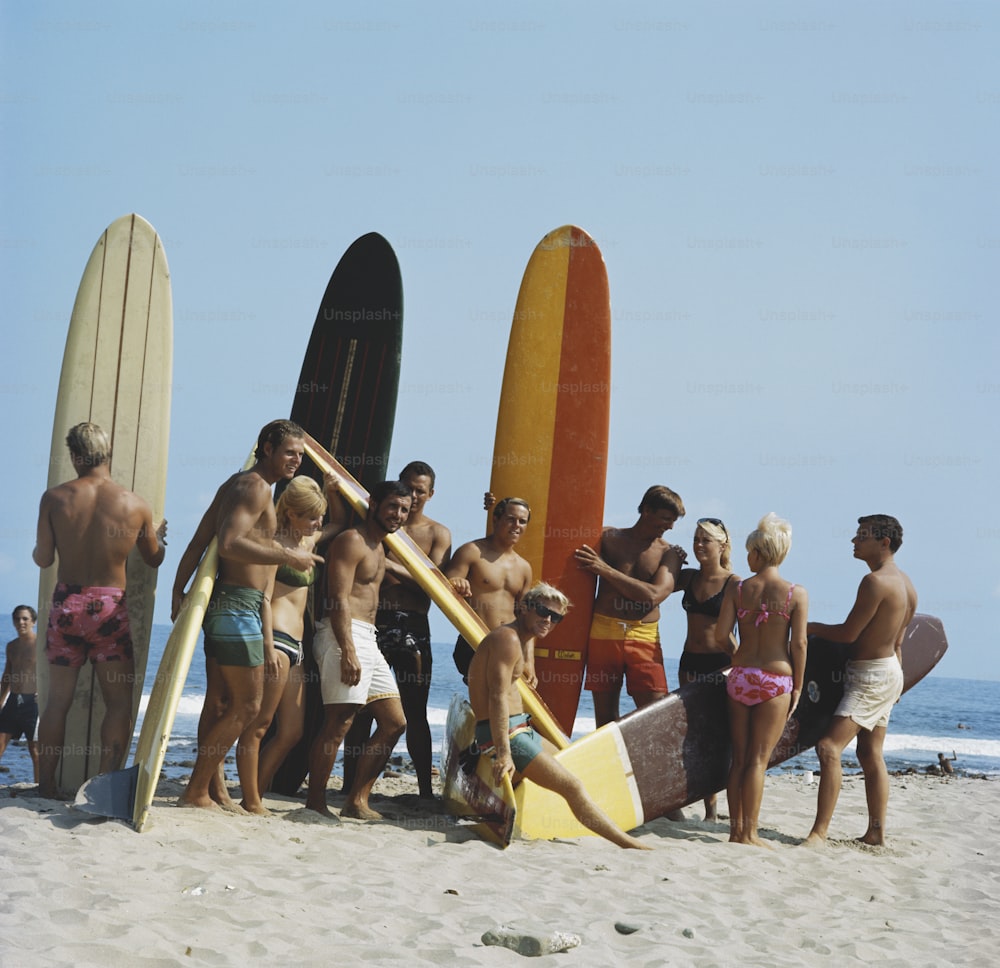 um grupo de pessoas em uma praia com pranchas de surf
