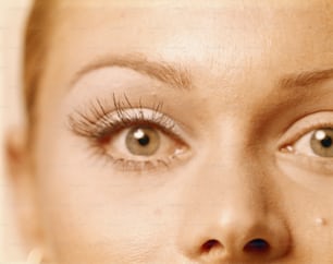 a close up of a woman's face with long lashes