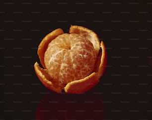Una naranja pelada sentada encima de una mesa