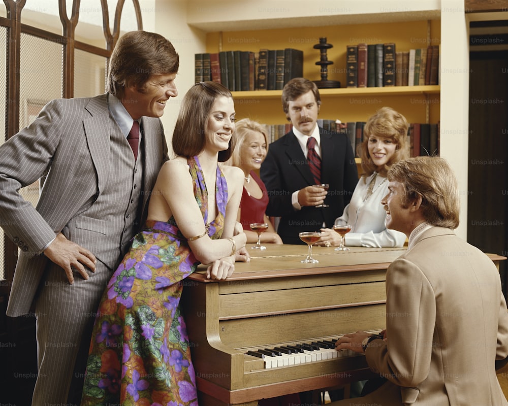 a group of people standing around a piano