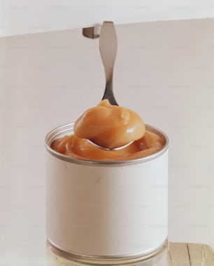 a can of caramel sauce with a spoon in it