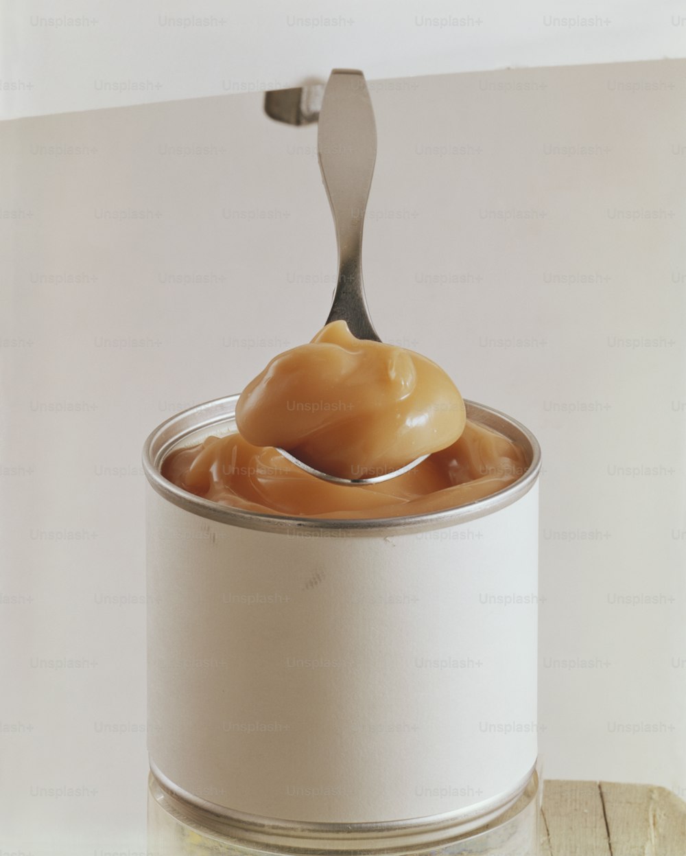 a can of caramel sauce with a spoon in it