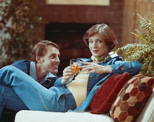 a man sitting next to a woman on a couch