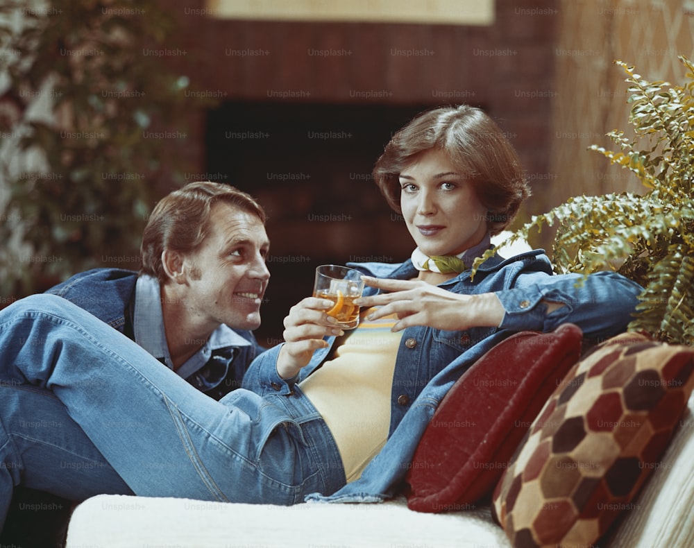 um homem sentado ao lado de uma mulher em um sofá