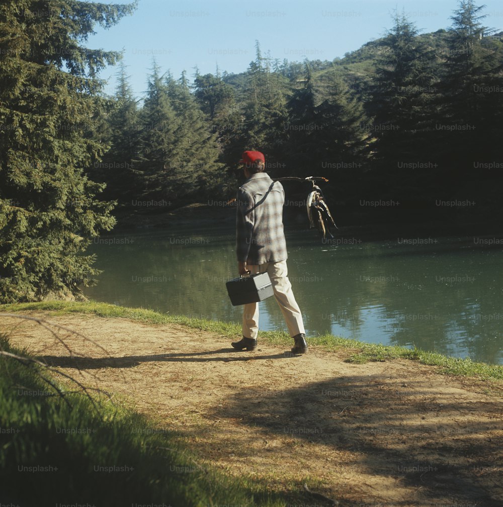 Ein Mann, der auf einem Feldweg neben einem See steht