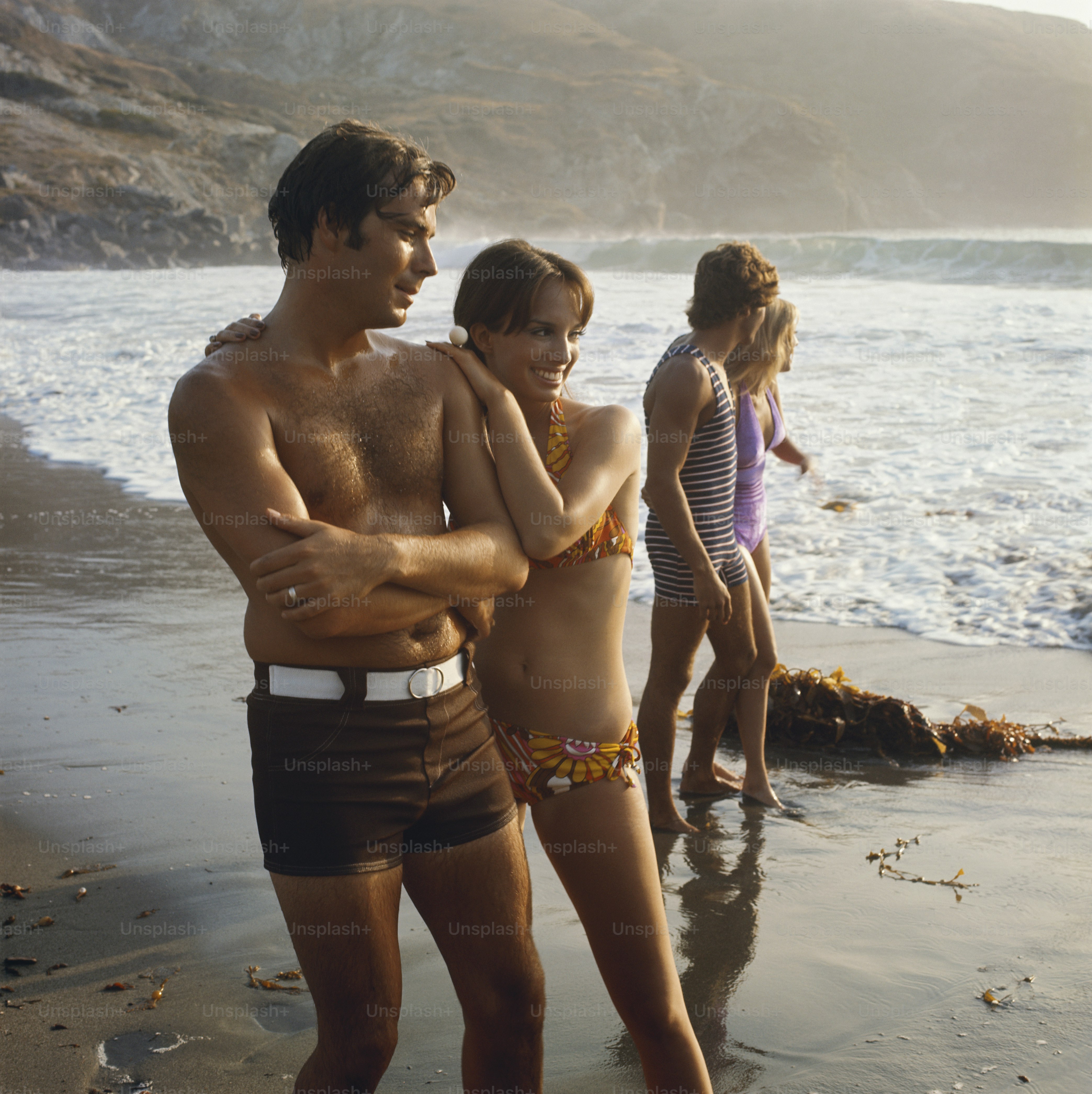 a couple of people that are standing in the sand