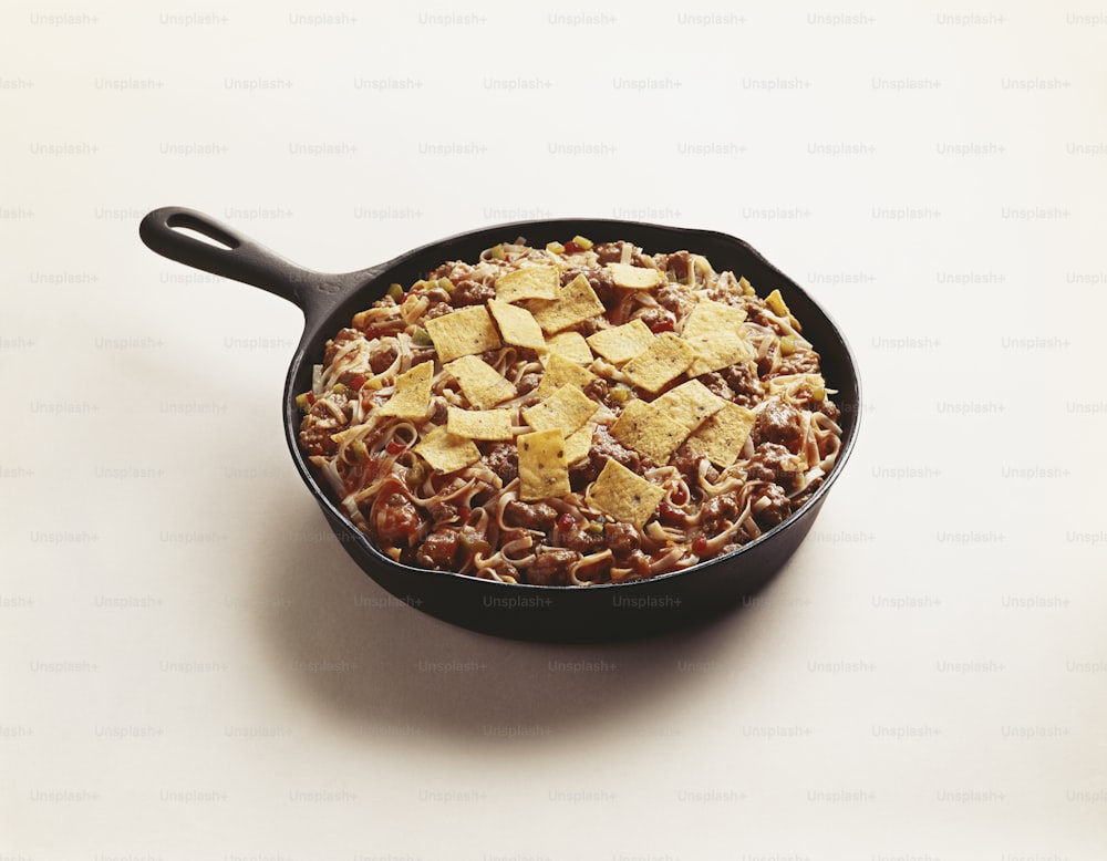 a skillet filled with beans and tortilla chips