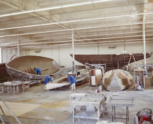 two men working on a boat in a building