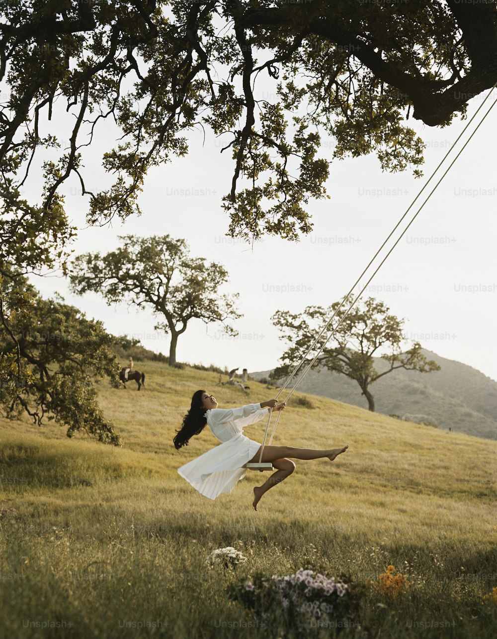 a woman flying through the air while wearing a white dress