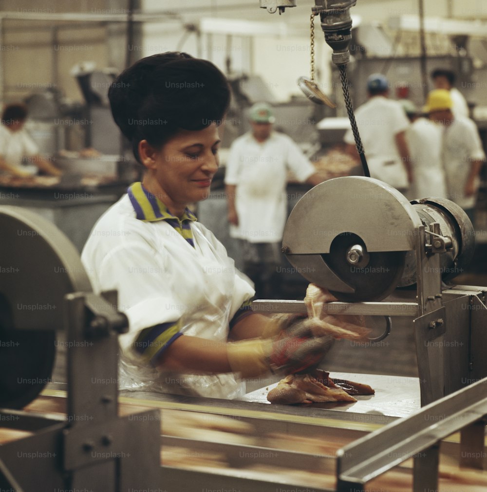 a woman in a factory working on a piece of meat