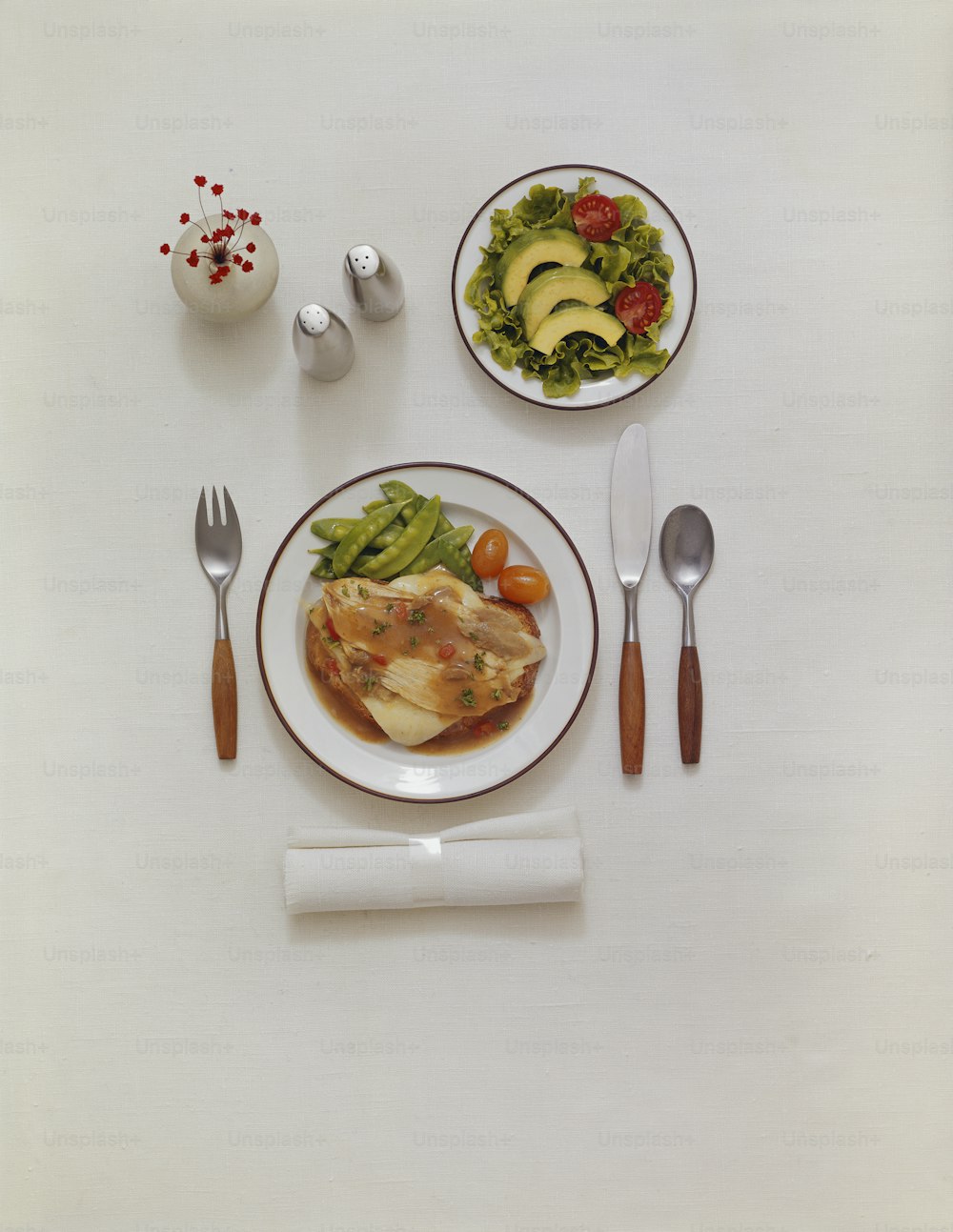 uma mesa branca coberta com pratos de comida e utensílios