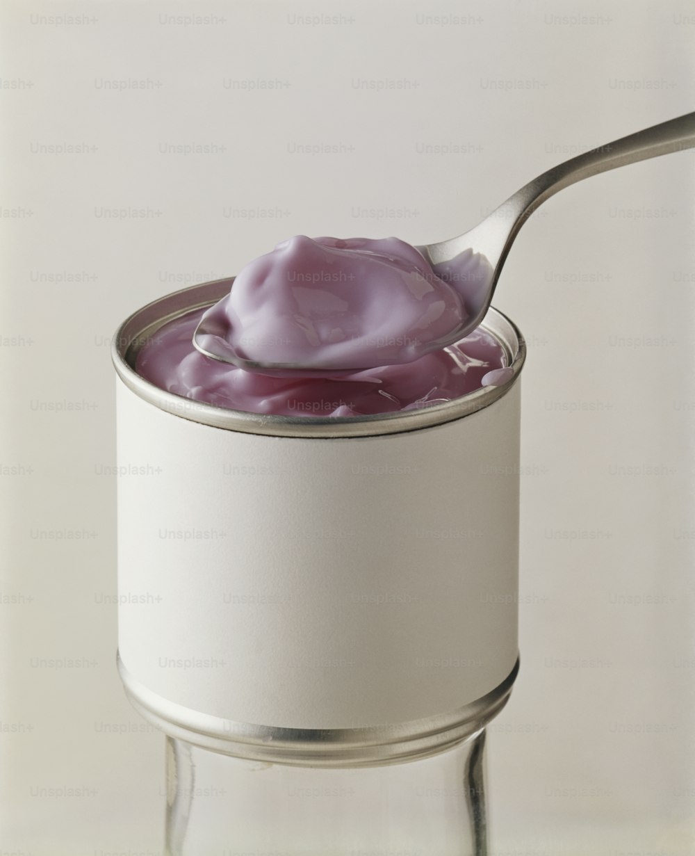 a spoon full of yogurt sitting on top of a can