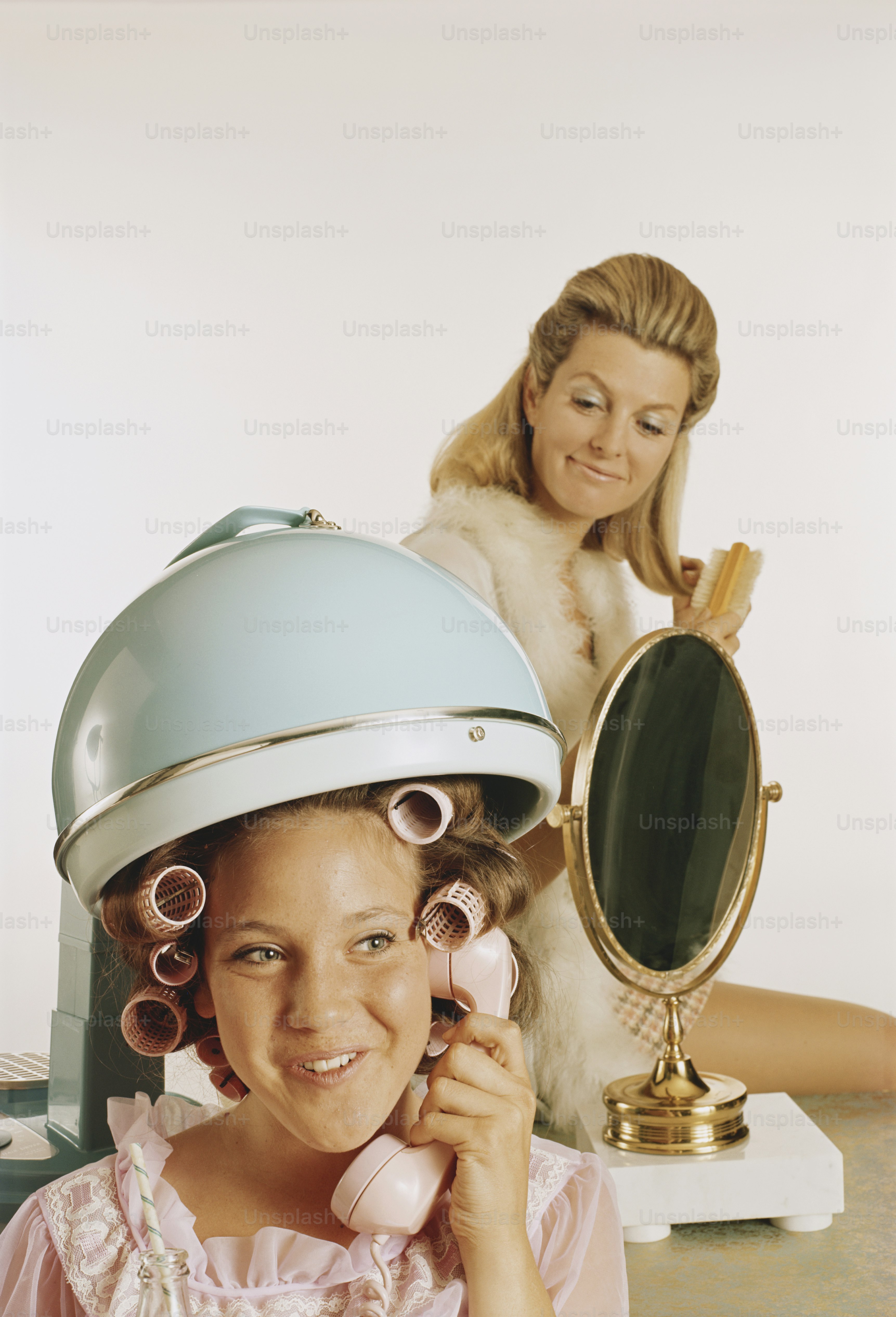 a woman is talking on a pink phone