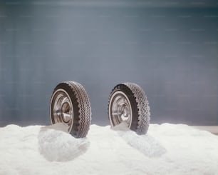 雪の山の上に座っているタイヤのペア
