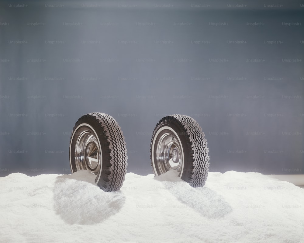 Ein Paar Reifen, die auf einem Schneehaufen sitzen