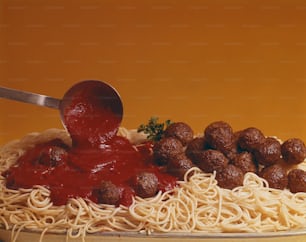 Un plato de espaguetis con albóndigas y salsa