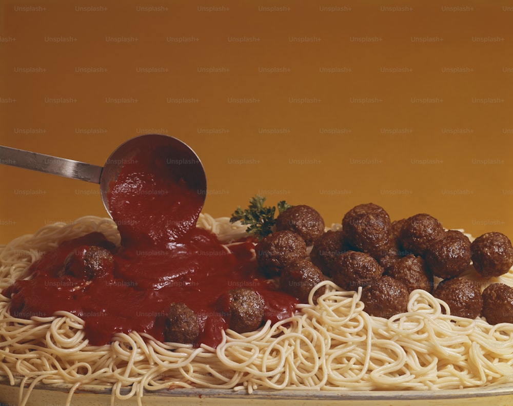 un piatto di spaghetti con polpette e sugo