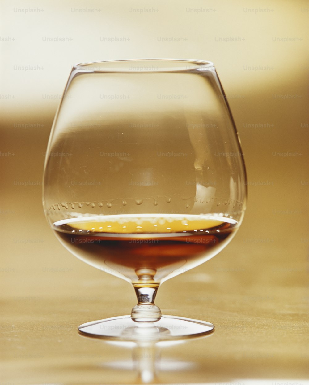 a wine glass filled with liquid on top of a table