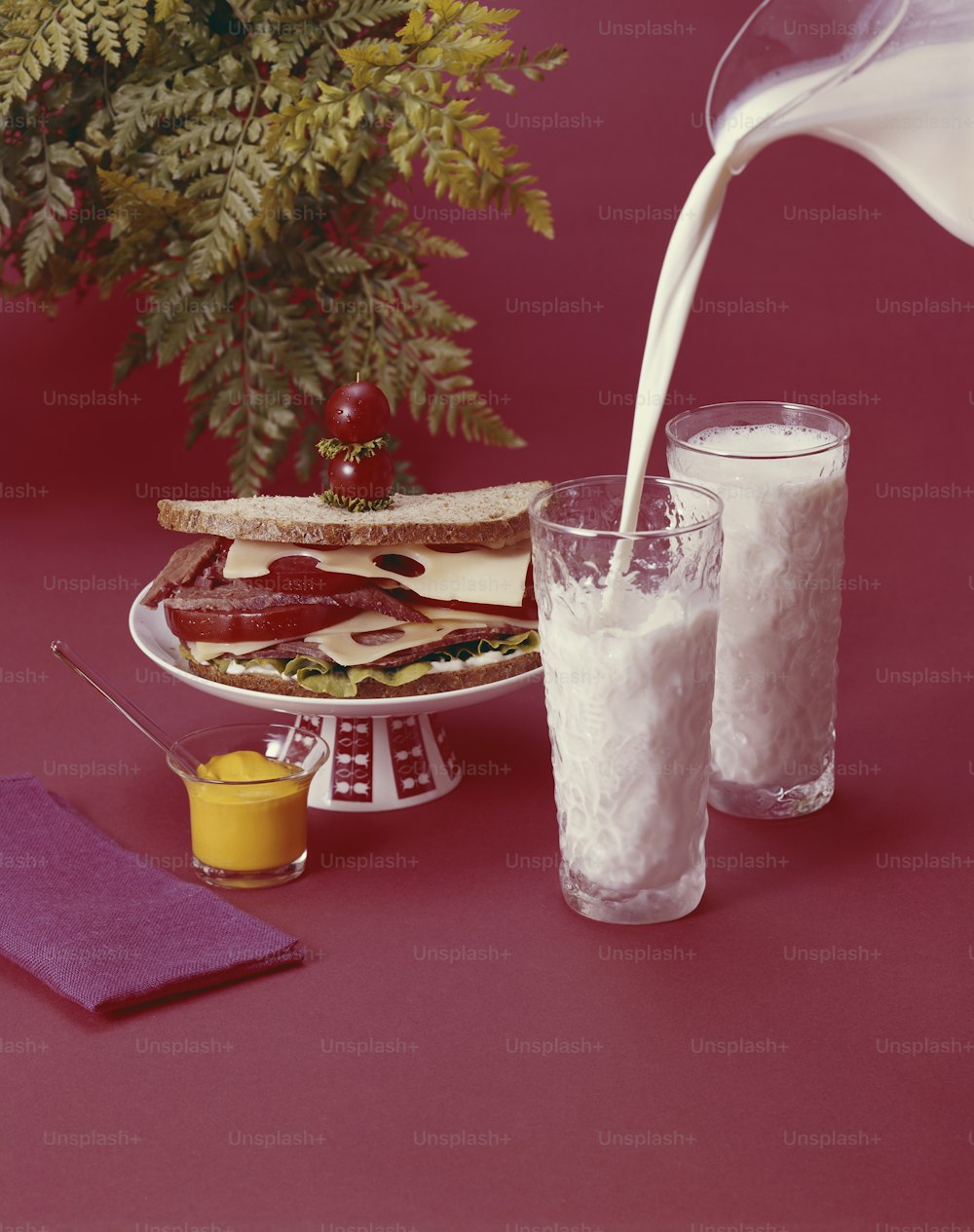 a glass of milk being poured into a plate of food