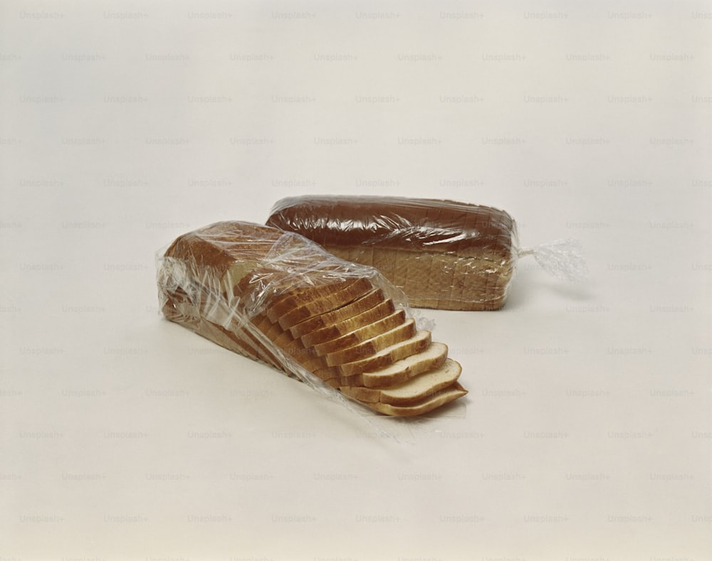 um pão e um pedaço de pão embrulhado em plástico