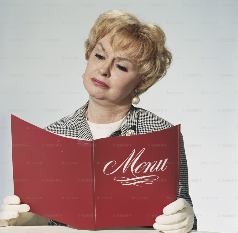 a woman sitting at a table reading a menu
