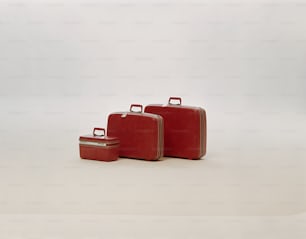three pieces of red luggage sitting next to each other