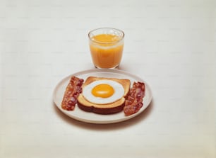 a white plate topped with bacon and a fried egg