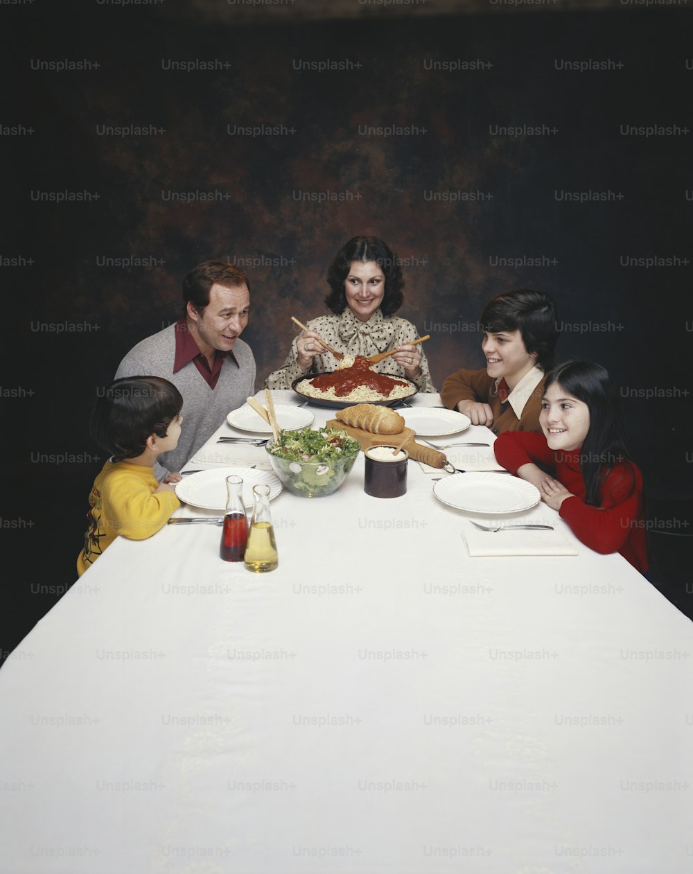 a group of people sitting around a white table