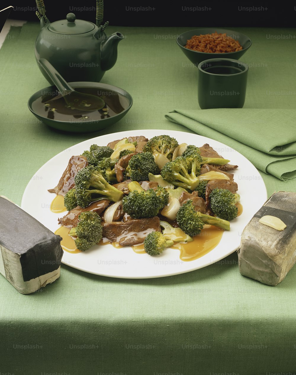 um prato branco coberto com carne e brócolis
