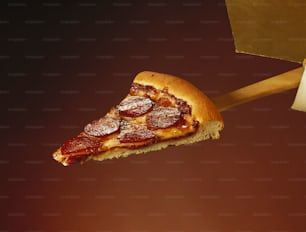 ein Stück Peperoni-Pizza, das von einem Holzspatel gehalten wird
