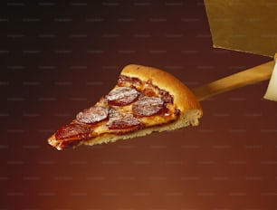 a slice of pepperoni pizza being held by a wooden spatula