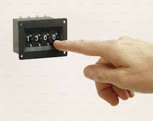 a hand pointing at a black and white clock