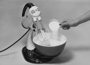 a person is mixing a bowl with a mixer