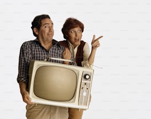 a man and a woman are holding a television