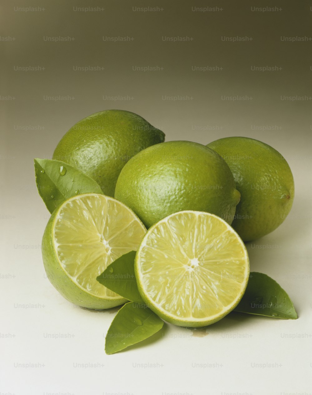 limes with leaves on a white background