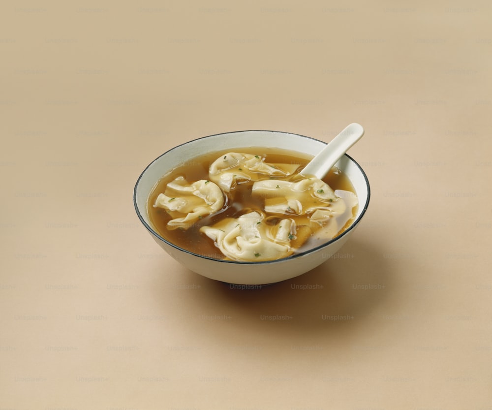 a bowl of soup with dumplings in it