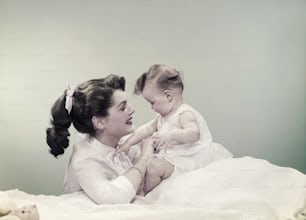 ベッドの上に赤ん坊を抱く女性