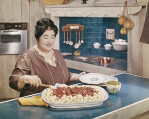 부엌에서 접시에 음식을 준비하는 여자