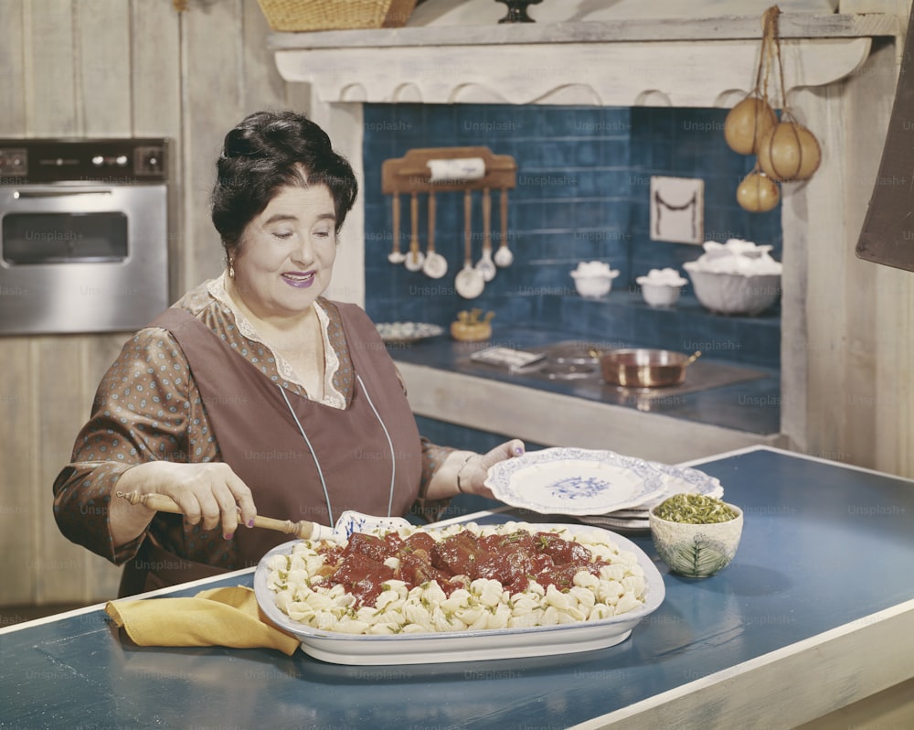 Una mujer en una cocina preparando comida en un plato