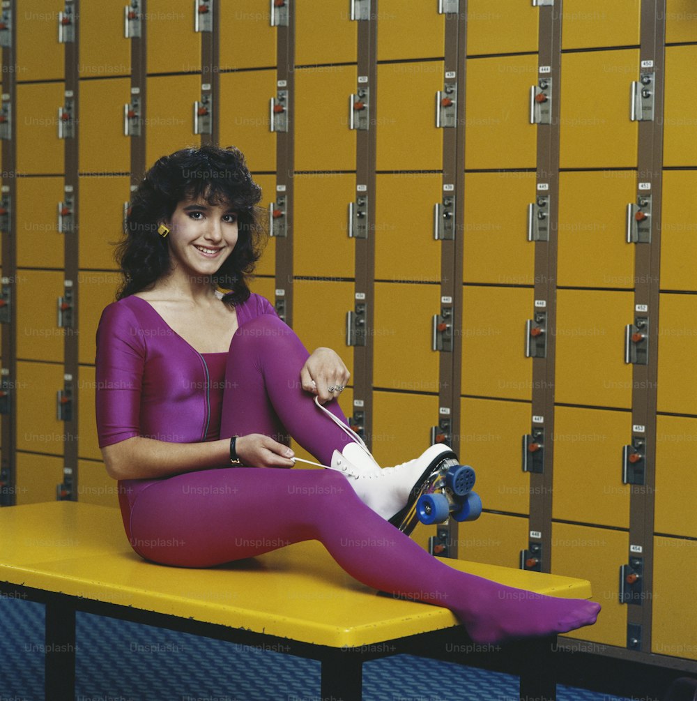 Une femme assise sur un banc devant des casiers