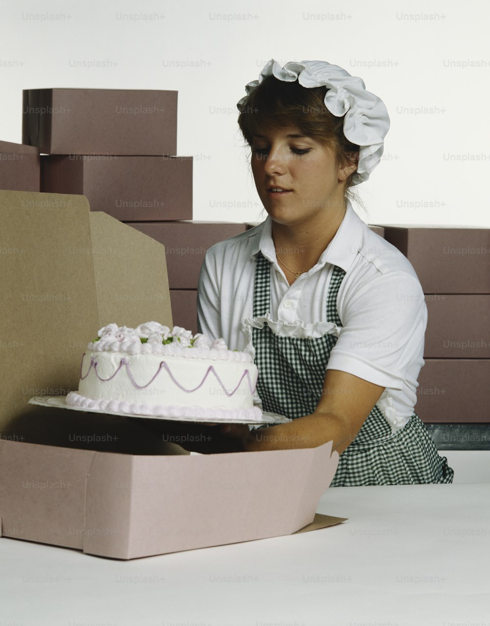 a woman in an apron is cutting a cake