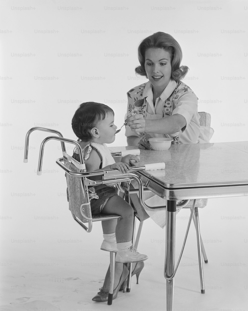 a woman sitting at a table with a small child