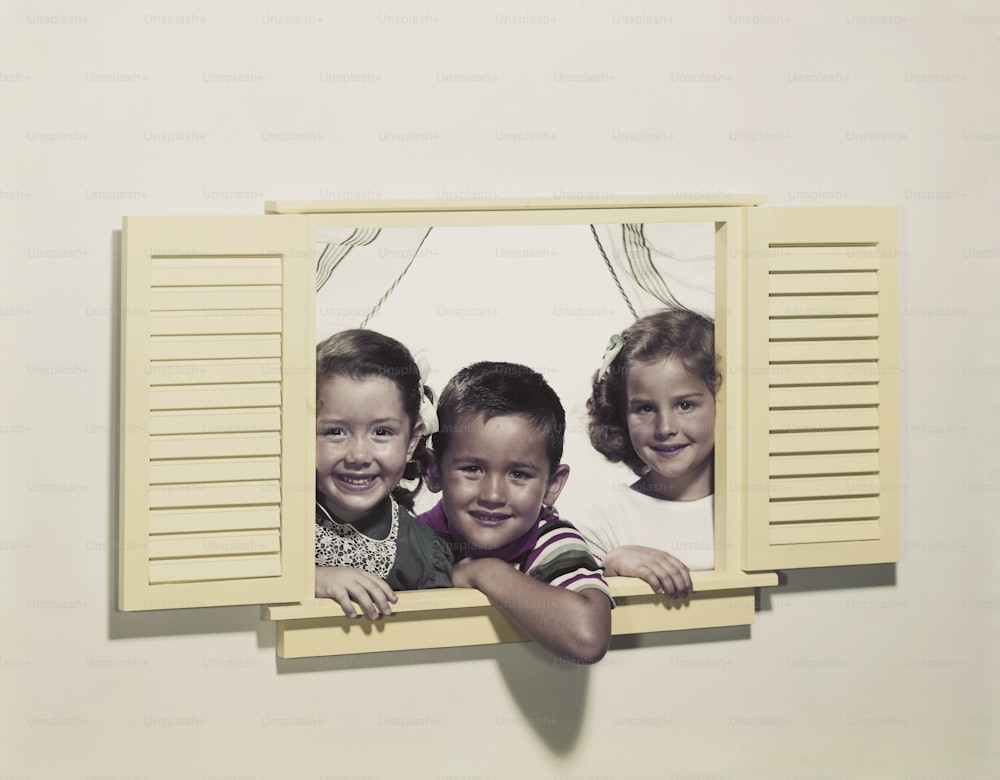 a couple of kids that are looking out of a window