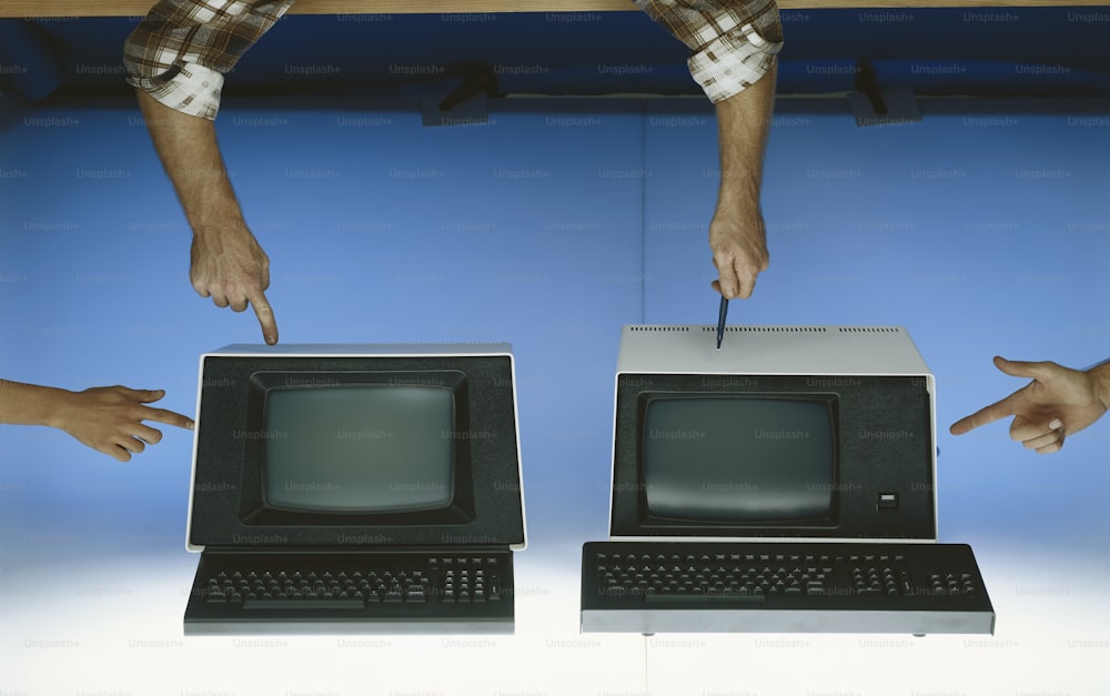 コンピューターのモニターとキーボードを指す両手