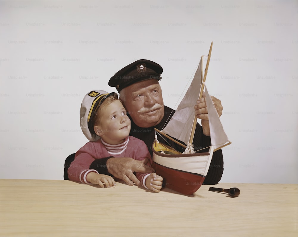 uma pintura de um homem segurando uma boneca ao lado de um barco